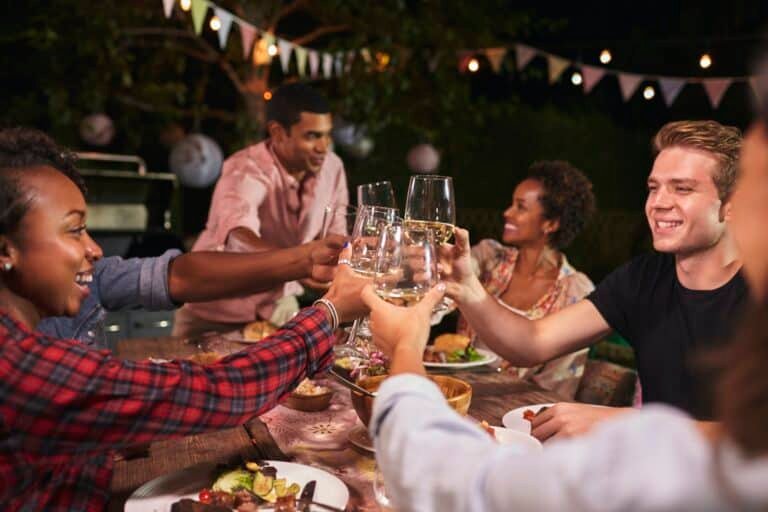 Friends and family toasting at garden dinner party, close up